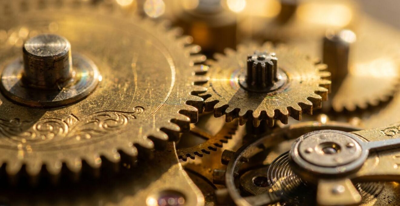 Macro close-up of interlocking brass gears representing the mechanical relationship between trustee and beneficiary roles